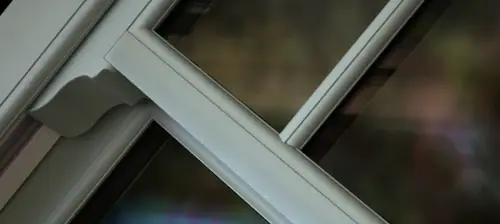 Close-up of a Spectus vertical sliding sash window showing the ultra-slim 37mm meeting rail, authentic sash detailing and cream woodgrain finish.